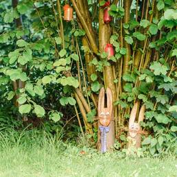 Geschnitzte Holzfiguren im Grünen beim Gastgarten