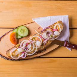 Belegtes Jausenbrot mit Radieschen und Zwiebelringen auf dem Holzbrett